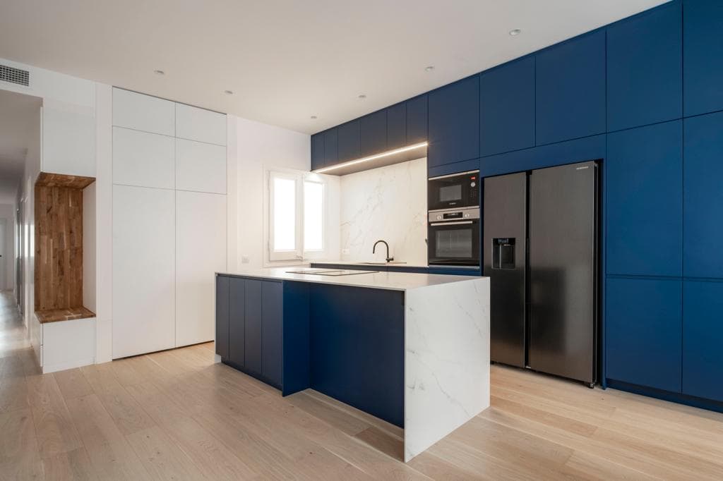 Encimera Calacatta en una cocina con mobiliario azul